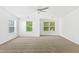 Large, neutral bedroom with 3 windows and a ceiling fan at 11710 Mezzanine Dr # 101, Raleigh, NC 27614