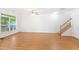 Spacious living room with gleaming floors, a large window, and staircase access to upper floors at 11710 Mezzanine Dr # 101, Raleigh, NC 27614