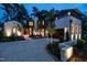 Beautiful two-story home with a painted brick exterior, dark trim, elegant lighting and a circular driveway at 1222 Duplin Rd, Raleigh, NC 27607