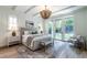 This main bedroom features hardwood floors, a large bed, a decorative rug, and French doors leading to the backyard at 1222 Duplin Rd, Raleigh, NC 27607