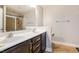 Bathroom featuring double sink vanity with dark cabinets, large mirror, and glass door shower at 124 Owensboro Ct, Raleigh, NC 27603