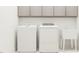 Clean laundry room with front-loading machines and storage cabinets above at 1244 Hazelnut Ridge Ln, Knightdale, NC 27545