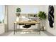Well-lit office space featuring built-in shelving, a modern desk, and ample natural light from the window at 1244 Hazelnut Ridge Ln, Knightdale, NC 27545