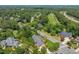 Aerial view of home, neighborhood, and golf course with green trees and a road cutting through the image at 129 Trellingwood Dr, Morrisville, NC 27560