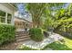 Spacious backyard with covered patio, brick steps, and lush landscaping at 129 Trellingwood Dr, Morrisville, NC 27560