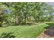 Expansive, well-manicured backyard with lush green grass and mature shade trees at 129 Trellingwood Dr, Morrisville, NC 27560
