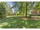 Expansive green backyard with mature trees, offering a peaceful and private outdoor space at 129 Trellingwood Dr, Morrisville, NC 27560