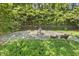 Outdoor stone patio area with a tranquil water fountain, surrounded by lush greenery and seating at 129 Trellingwood Dr, Morrisville, NC 27560