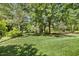 Spacious backyard featuring lush green grass and mature shade trees for privacy and enjoyment at 129 Trellingwood Dr, Morrisville, NC 27560