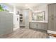 Bright bathroom featuring a tiled shower, wood-look flooring, and shaker cabinetry at 129 Trellingwood Dr, Morrisville, NC 27560