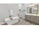 Beautiful bathroom with a soaking tub, modern fixtures, and gray shaker cabinetry at 129 Trellingwood Dr, Morrisville, NC 27560