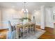 Bright dining room showcases a stylish chandelier, wainscoting, and a rustic table set for an elegant meal at 129 Trellingwood Dr, Morrisville, NC 27560