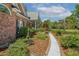 Brick home featuring manicured garden beds with a pathway leading to the front porch at 129 Trellingwood Dr, Morrisville, NC 27560