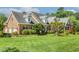 Side angle of a brick house featuring a well-maintained lawn and a classic architectural design at 129 Trellingwood Dr, Morrisville, NC 27560