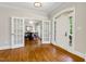 Home foyer featuring hardwood floors, glass paneled doors, and a glimpse into an adjacent room at 129 Trellingwood Dr, Morrisville, NC 27560