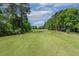 Beautiful view of golf course surrounded by mature trees and blue sky with a few white clouds at 129 Trellingwood Dr, Morrisville, NC 27560