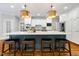 Kitchen island with seating, pendant lights, and stainless steel appliances at 129 Trellingwood Dr, Morrisville, NC 27560