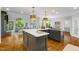 Bright, open kitchen with a large island, hardwood floors, modern lighting and views of the living room at 129 Trellingwood Dr, Morrisville, NC 27560