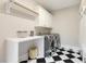 Well-equipped laundry room with washer, dryer, work surface and black and white tile at 129 Trellingwood Dr, Morrisville, NC 27560