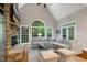 Bright living room featuring a stone fireplace, large windows with backyard views, and comfortable seating at 129 Trellingwood Dr, Morrisville, NC 27560