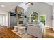 Bright living room with a stone fireplace, vaulted ceiling, large windows, and comfortable seating at 129 Trellingwood Dr, Morrisville, NC 27560