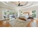 Spacious main bedroom features a trey ceiling, neutral colors, hardwood floors, and doors to a sunroom at 129 Trellingwood Dr, Morrisville, NC 27560