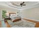 Spacious main bedroom with a trey ceiling, neutral colors, hardwood floors, and natural light at 129 Trellingwood Dr, Morrisville, NC 27560