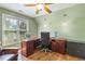 Bright office space with natural light from a large window, featuring a wooden desk, and a ceiling fan at 129 Trellingwood Dr, Morrisville, NC 27560