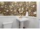 Charming powder room with custom floral wallpaper and elegant pedestal sink at 129 Trellingwood Dr, Morrisville, NC 27560