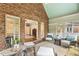 Comfortable sunroom with exposed brick and lots of natural light, with a peek into the Main Bedroom at 129 Trellingwood Dr, Morrisville, NC 27560
