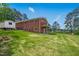 Brick home featuring backyard, deck, and lush lawn at 1415 Clearwater Dr, Sanford, NC 27330