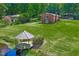 Charming red brick home featuring a gazebo on a lush green lawn near a serene waterfront at 1415 Clearwater Dr, Sanford, NC 27330