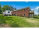Spacious backyard features a manicured lawn, brick home with deck, and separate storage building at 1415 Clearwater Dr, Sanford, NC 27330