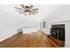 Bright, minimalist living room with a wooden floor, modern ceiling fan, and a charming brick fireplace at 1415 Clearwater Dr, Sanford, NC 27330