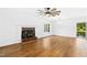 Well-lit living room with a fireplace, modern ceiling fan, and large windows showcasing scenic lake views at 1415 Clearwater Dr, Sanford, NC 27330