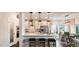 Well-lit kitchen with white cabinetry, stainless appliances, an island with stools, and an adjacent dining area at 1428 Goldfinch Perch Ln, Knightdale, NC 27545