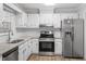 Bright kitchen features white cabinets, stainless appliances, granite countertops, and wood-look flooring at 1442 Aversboro Rd # 7, Garner, NC 27529