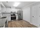 Bright kitchen features white cabinets, stainless appliances, granite countertops, and wood-look flooring at 1442 Aversboro Rd # 7, Garner, NC 27529