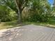 Large backyard with a big tree, green grass, and a wood deck at 1521 N Duke St, Durham, NC 27701
