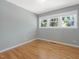Light-filled bedroom with hardwood floors and three windows showcasing the outdoor greenery at 1521 N Duke St, Durham, NC 27701