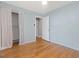 Bedroom with wood floors, light walls, window with privacy blinds, and a closet with curtain at 1521 N Duke St, Durham, NC 27701