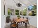 Sunroom with white-painted walls, tile flooring, and outdoor views through the large windows at 1521 N Duke St, Durham, NC 27701