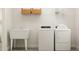 Functional laundry room with sink, modern washer and dryer, and storage shelves at 1581 Goldfinch Perch Ln, Knightdale, NC 27545