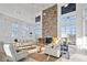 Bright, open living room features a floor-to-ceiling stone fireplace and large windows at 1581 Goldfinch Perch Ln, Knightdale, NC 27545