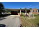 Quaint brick home featuring a covered carport and a charming front entrance with a white railing at 167 Chic Ennis Rd, Coats, NC 27521