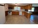 Kitchen with wooden cabinets, white appliances, tile floors and an adjacent dining area at 167 Chic Ennis Rd, Coats, NC 27521