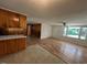 Open-concept space with wood floors, kitchen cabinets, and ample natural light from the large windows at 167 Chic Ennis Rd, Coats, NC 27521