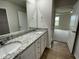 A well-lit bathroom with a granite countertop, dual sinks, and wood-look floors at 167 Lotus Ave, Smithfield, NC 27577