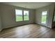 A bright and airy bedroom features luxury vinyl flooring and a sliding glass door to the backyard at 167 Lotus Ave, Smithfield, NC 27577