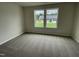 This bedroom features neutral carpet, two windows with wooded views, and soothing neutral paint at 167 Lotus Ave, Smithfield, NC 27577